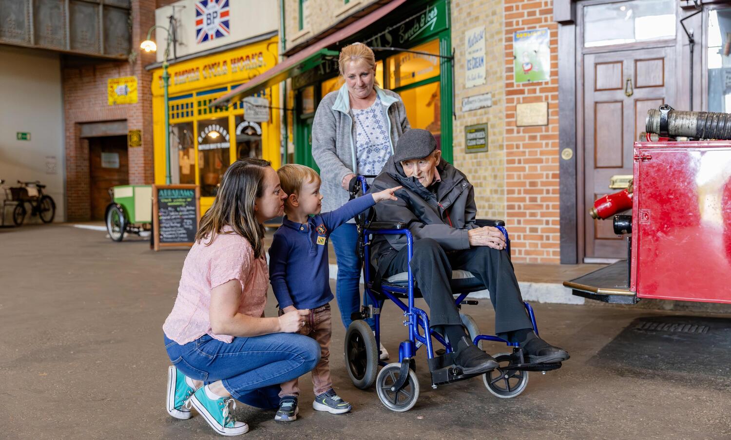A multi-generational family visiting the museum with grandad in a wheelchair