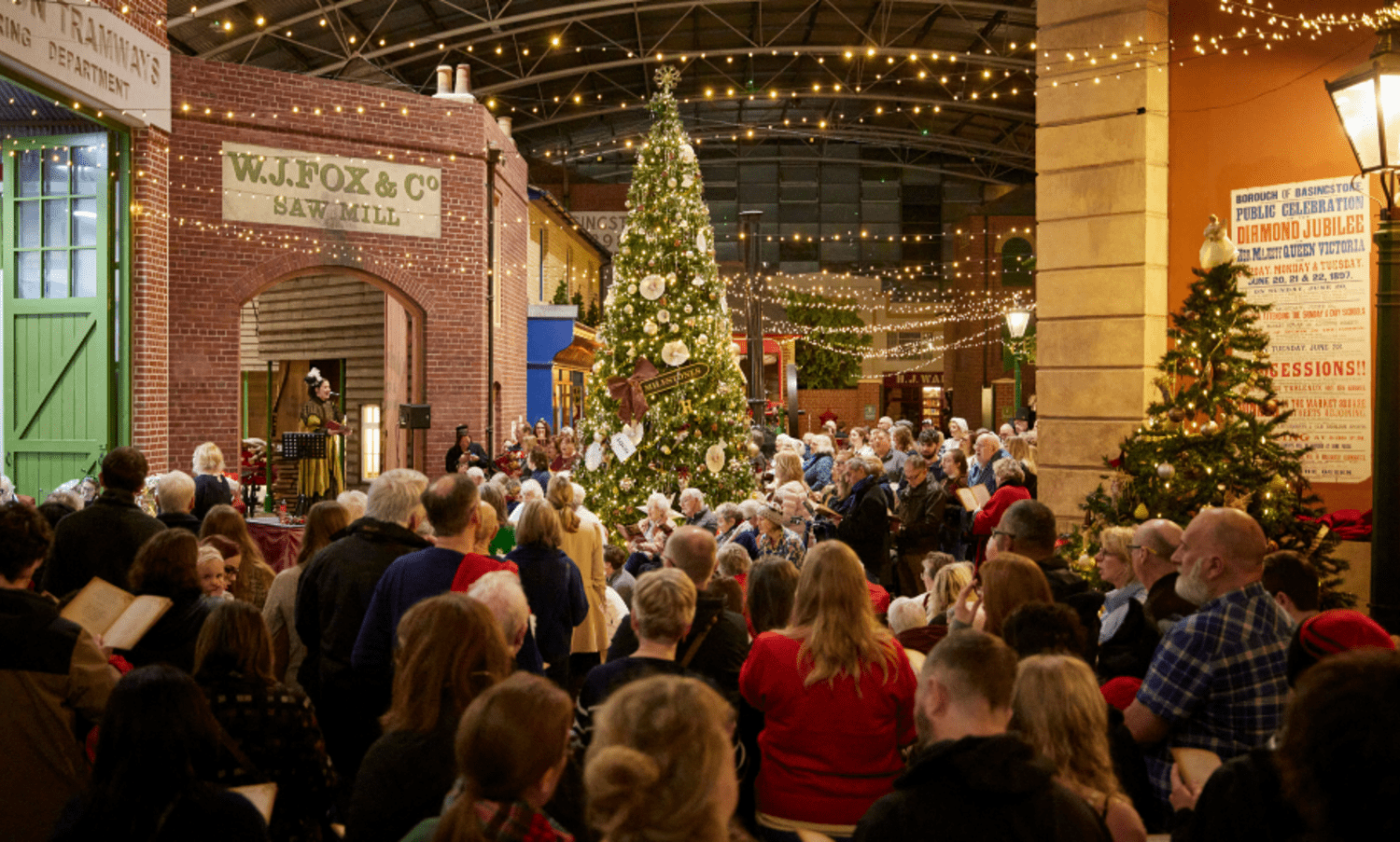 Group of carolers underneath the Christmas tree