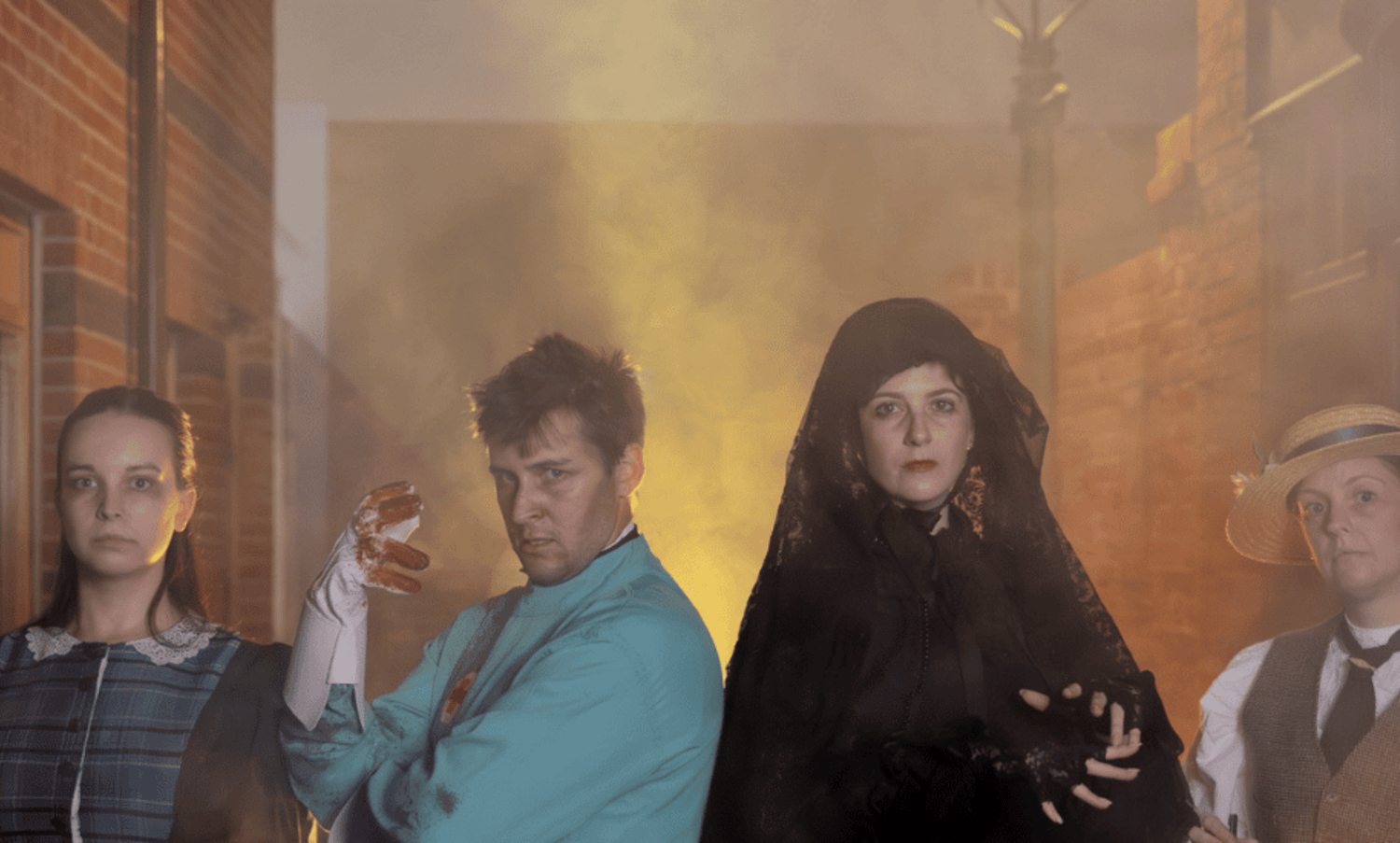 Four costumed spooky characters in smokey street