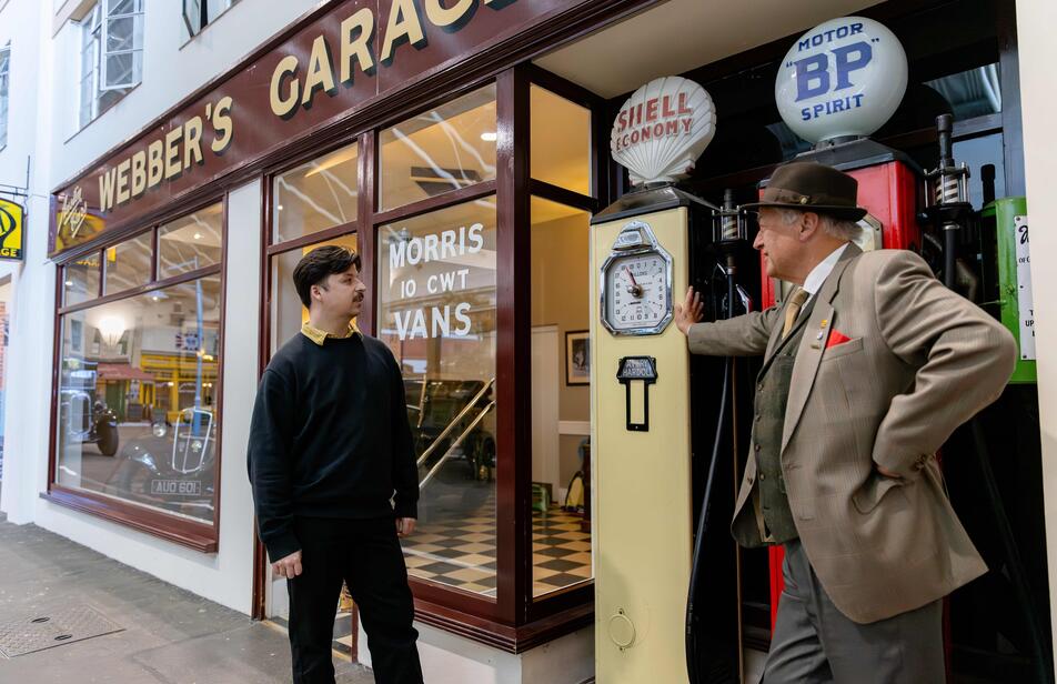 Costumed garage owner greets a visitor