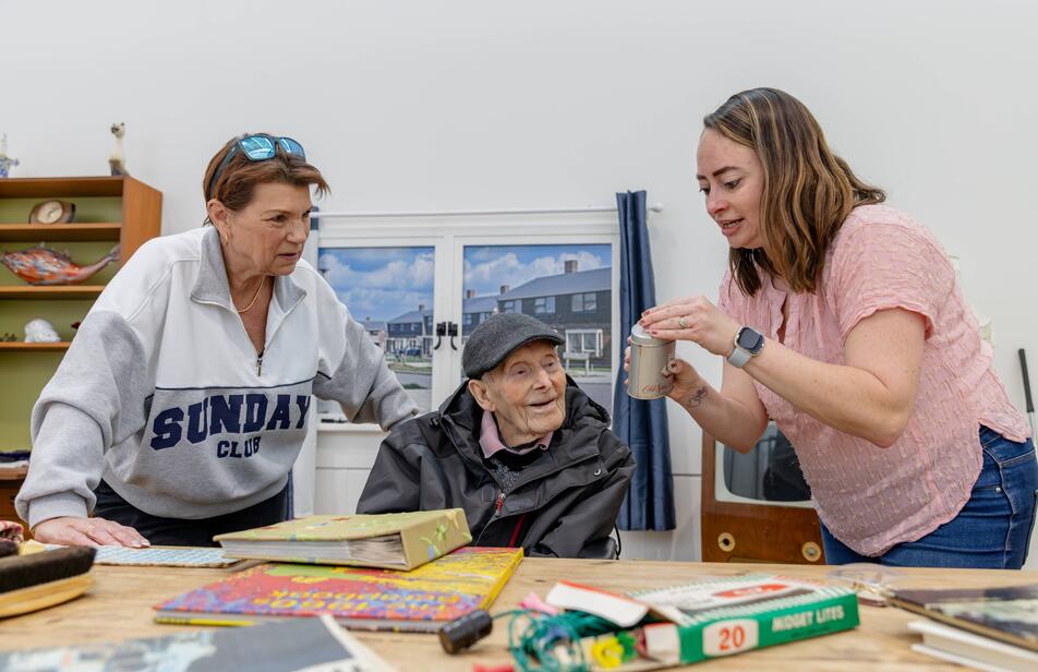 Older gentleman enjoying the memory lounge with two female family members