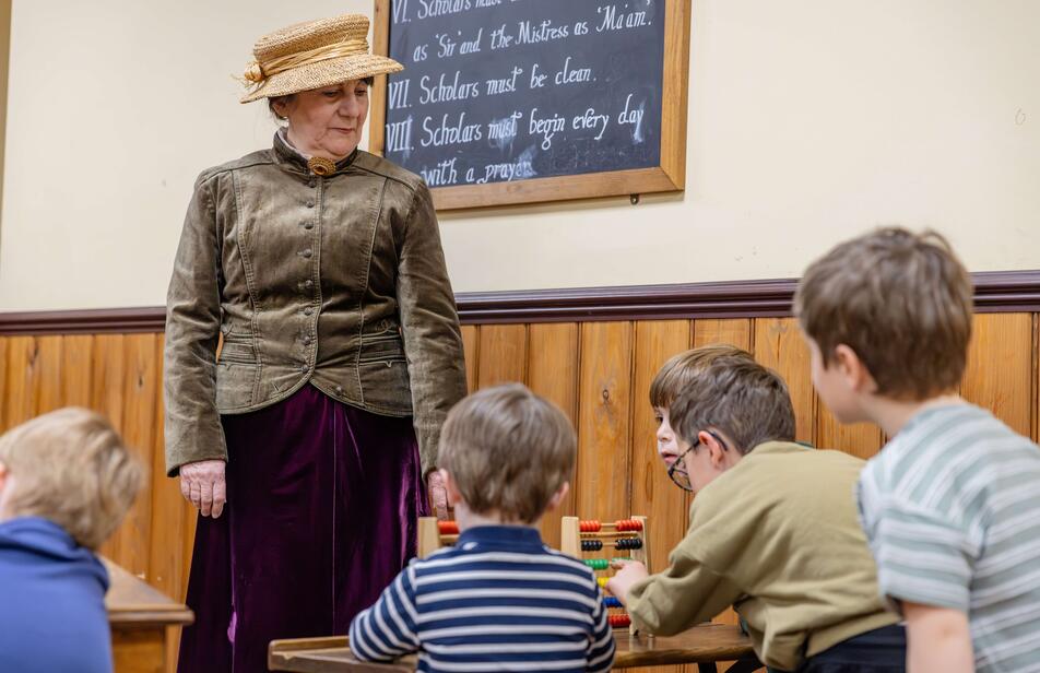 Costumed teacher with a selection of children in the Victorian Classroom