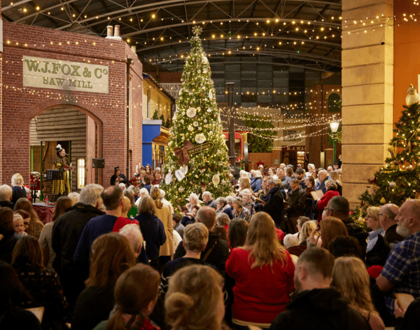 Group of carolers underneath the Christmas tree