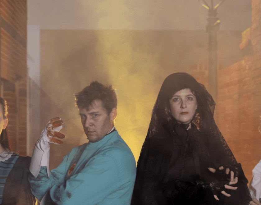 Four costumed spooky characters in smokey street