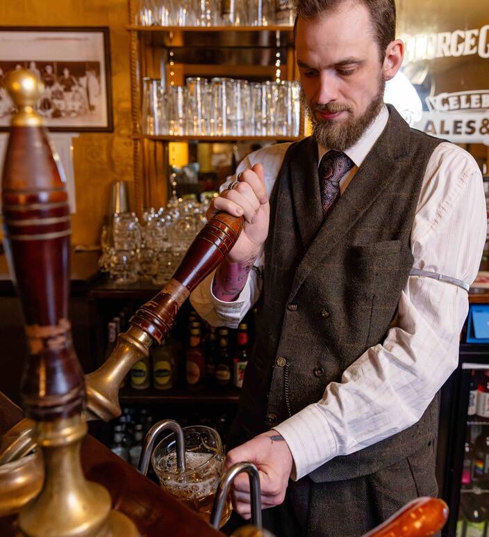 Member of staff serving beer in our pub