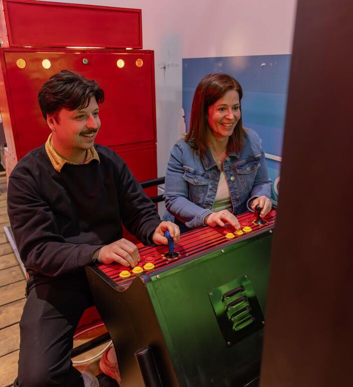 Two friends playing on a retro arcade machine